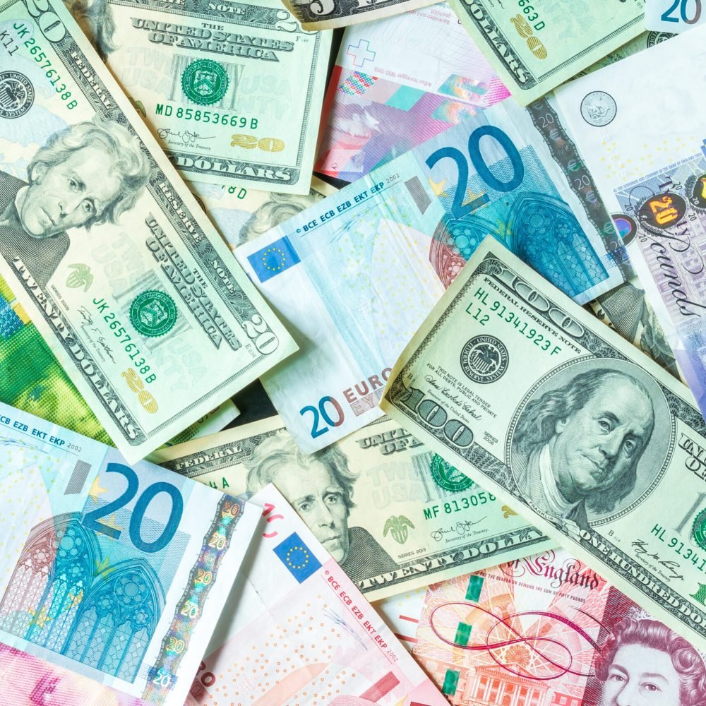 Lot of euro, US dollars, pounds bills, banknotes on wooden table close up. money cash finance budget business concept, top view.