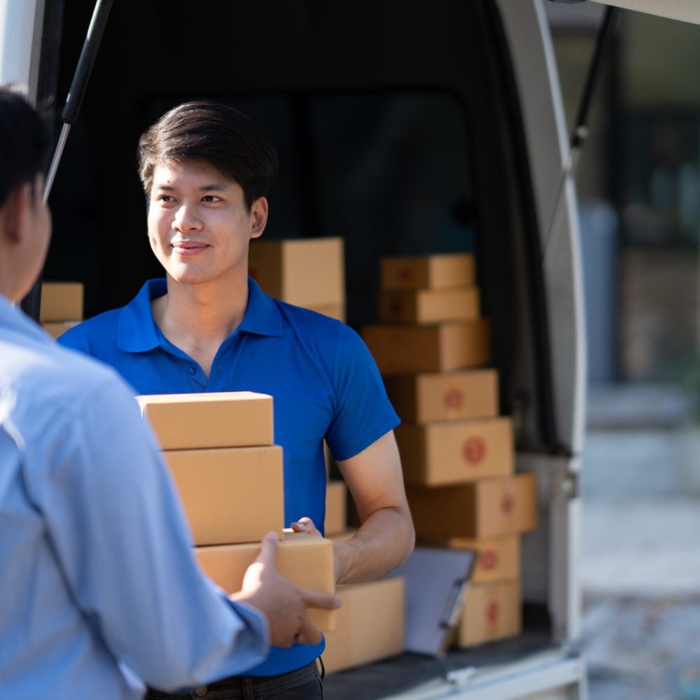 Young delivery man delivering and handing parcel box to customer.